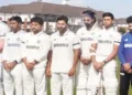 Players wear black armbands, observe a minute's silence