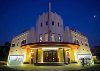 The illuminated facade of a cinema hall in India at night